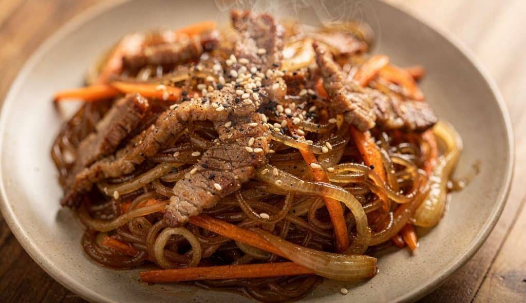 Japchae : vermicelles au porc, carottes et oignons